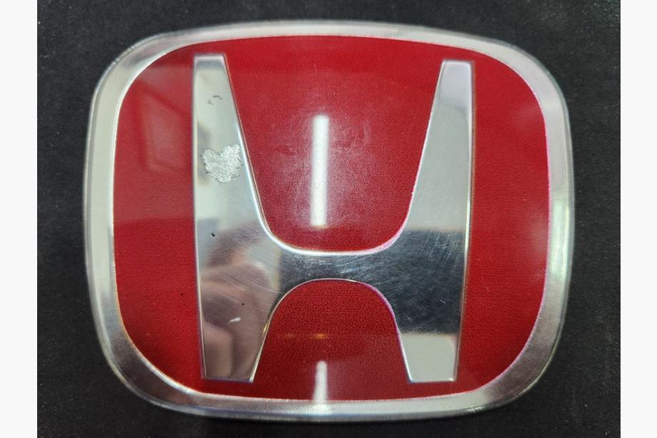Honda Emblēma (sarkana, pašlīmējoša) Izpārdošana 113 mm uz 93 mm (attālums starp stiprinājumiem 50 mm) Foto 1